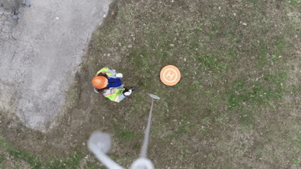 A community health worker detaches a package of PPE delivered by drone.