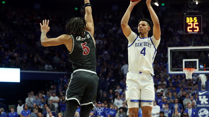 Kentucky's Tre Mitchell (4) shoots over the defense of Saint Joseph's Lynn Greer III (5)...
