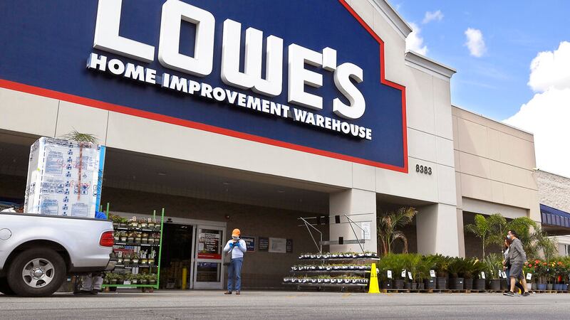 In this March 22, 2020 file photo, customers walk into a Lowe's home improvement store in the...